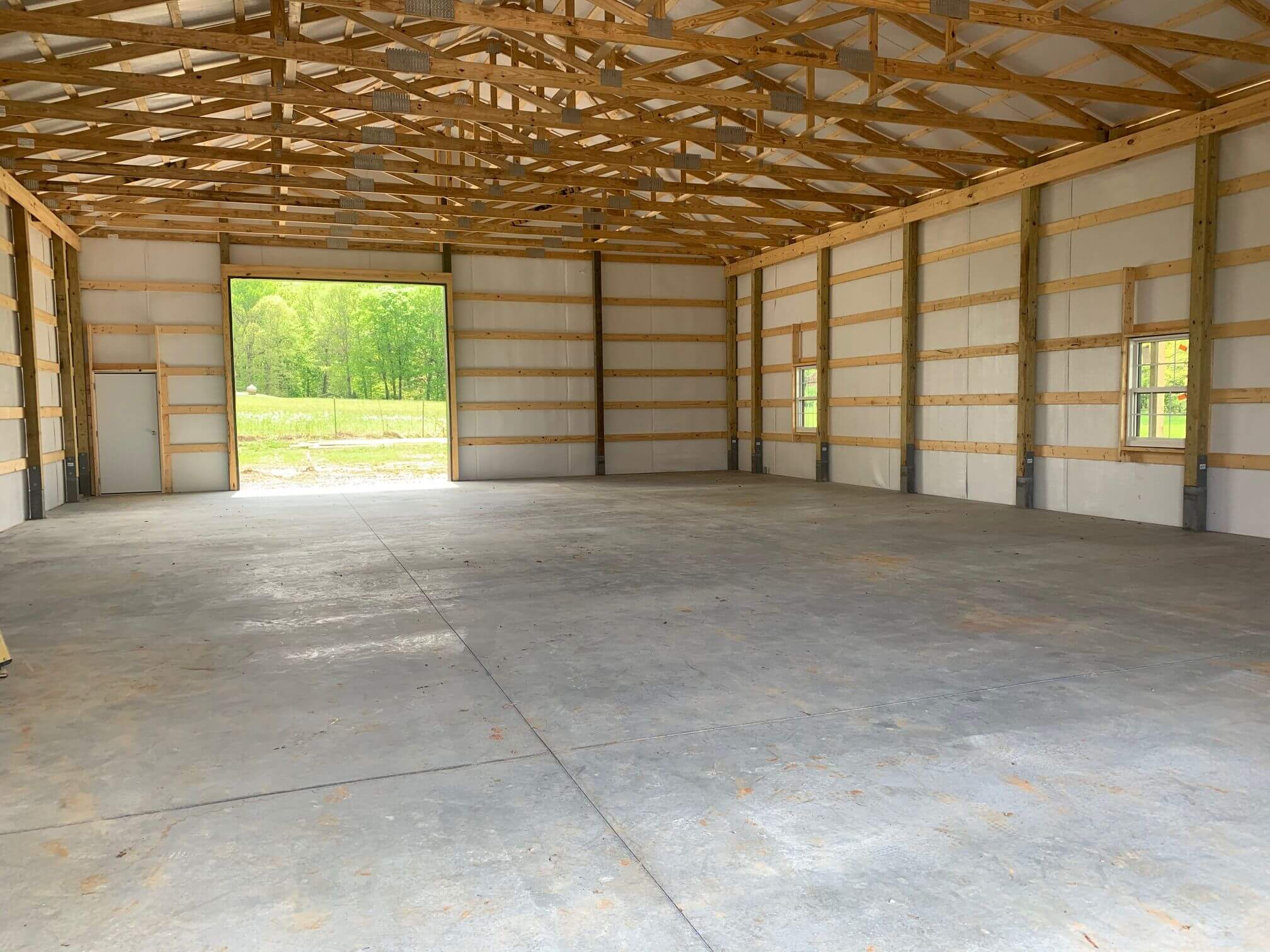 Photo of interior of barn with wood trusses