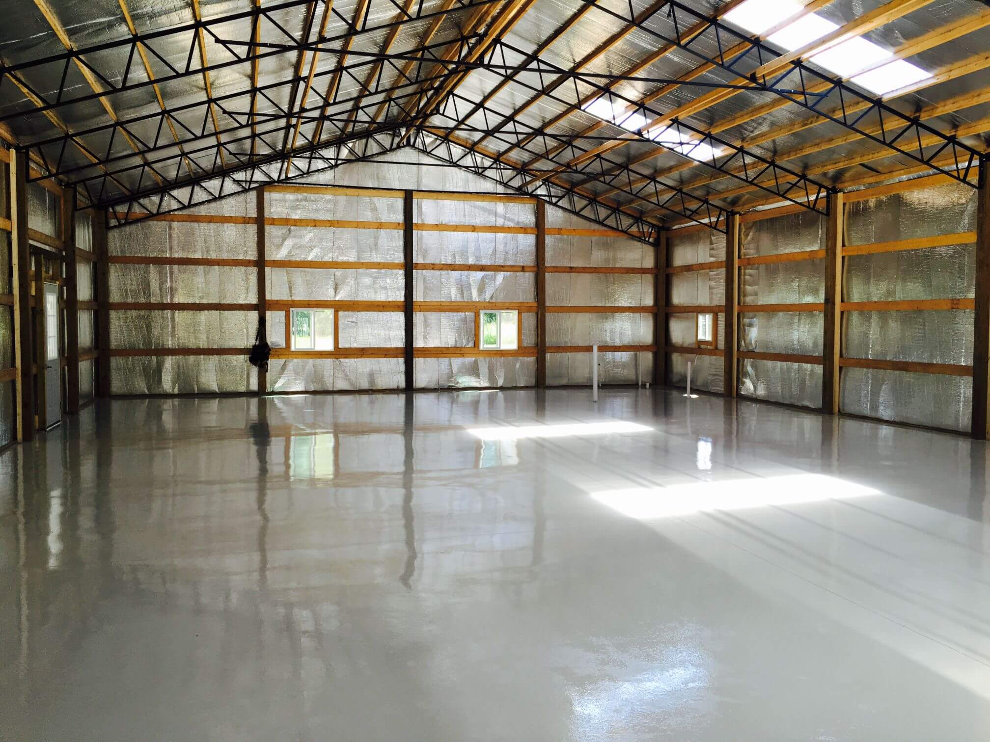 Photo of interior of post frame building with steel trusses